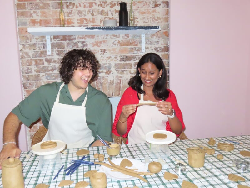 A couple at a pottery class make clay creations