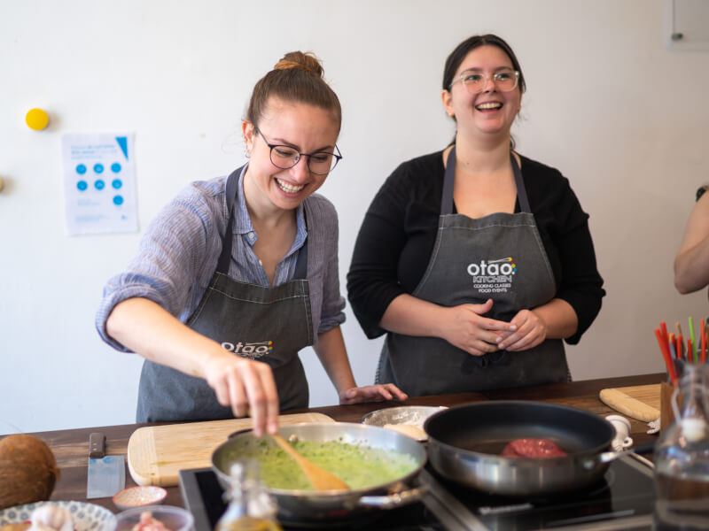 A couple cooking and laughing together at a cooking class date night