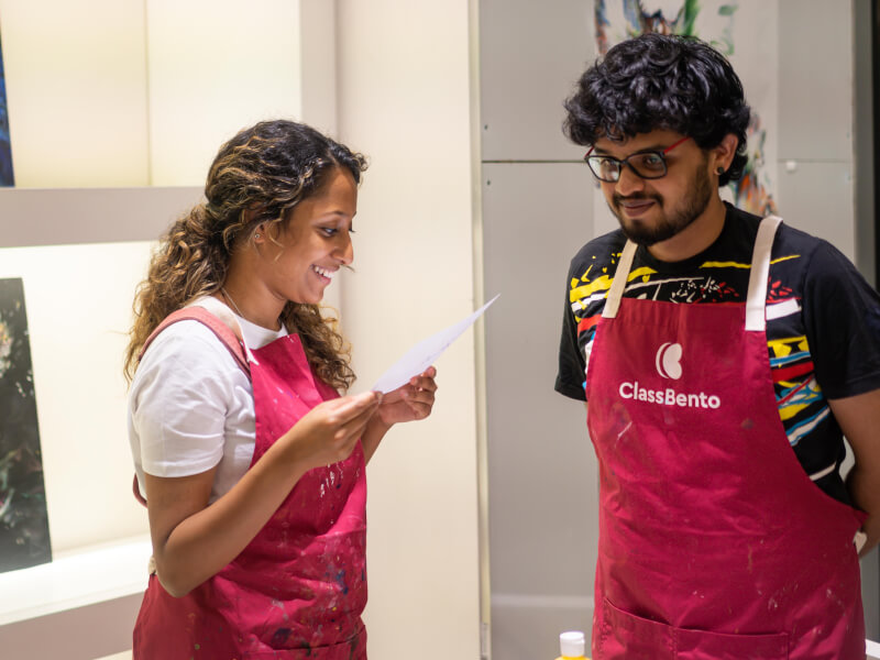 Couple smiling at a fluid art class on their date night