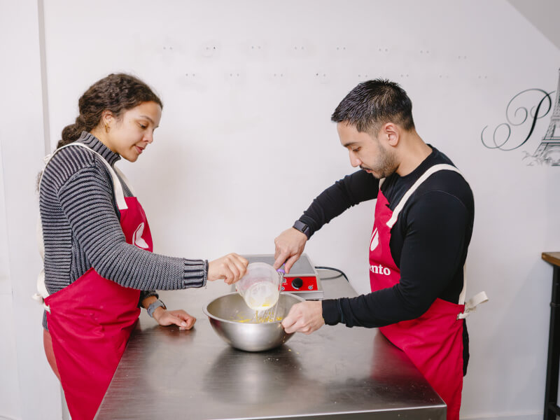 A couple share a mixing bowl at a cooking class