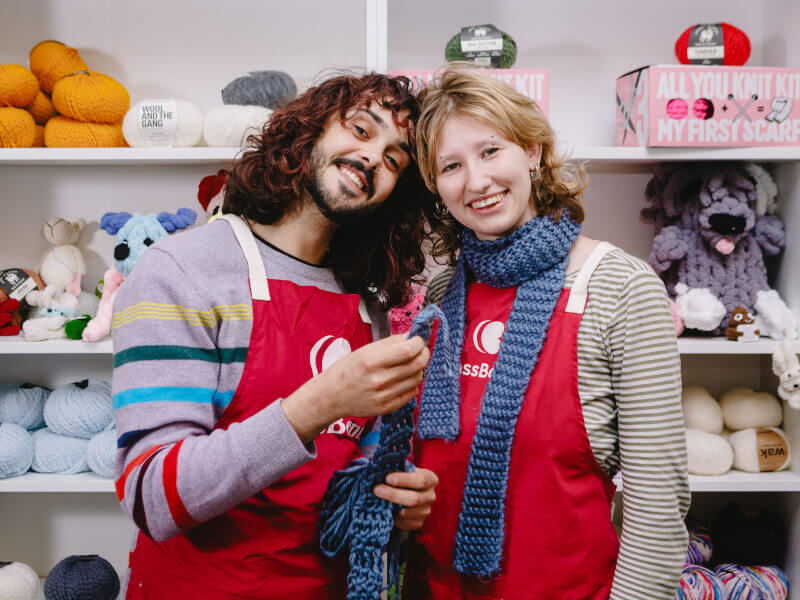 A couple in ClassBento aprons wear their handmade scarves