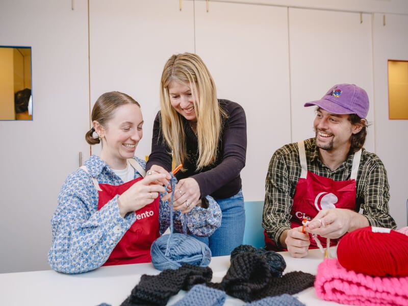 A couple smiling while learning to crochet in a crochet class
