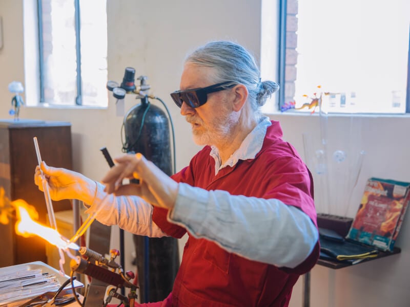 A man melting glass at a glassblowing workshop