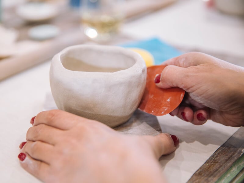 A womans hands moulding a clay cup at a Mother's Day pottery experience