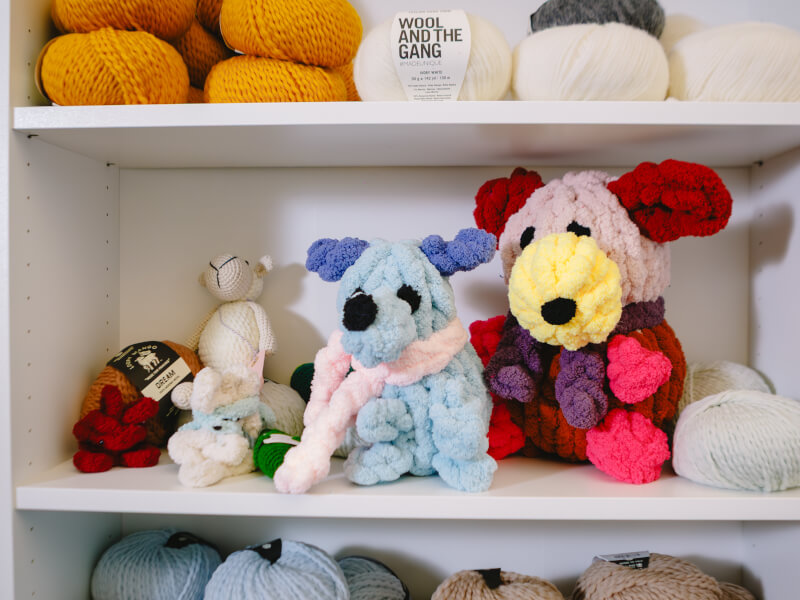 A collection of hand knitted animals in a textiles studio