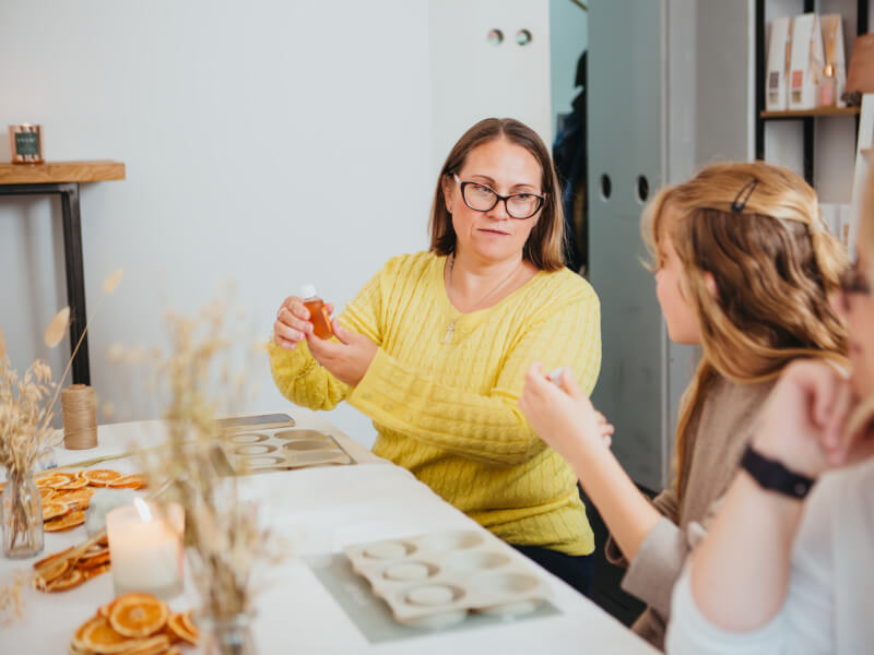 Two women having a chat and sniffing essential oils at a soap making class