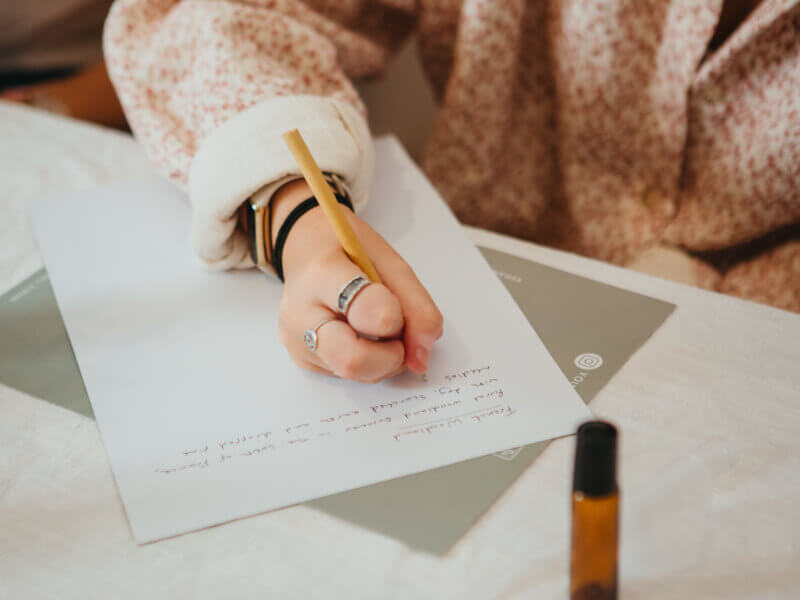Close up of hands writing a letter on paper