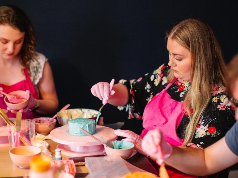 A woman at a cake decorating class she got as a gift for Mother's Day