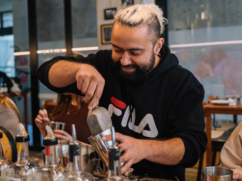 A man enjoys making cocktails for his birthday
