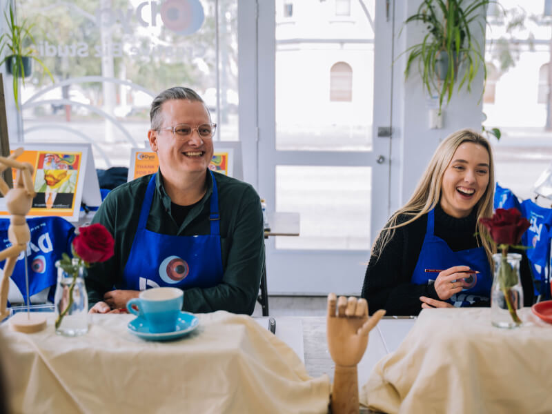 A father-daughter duo enjoy a painting class together