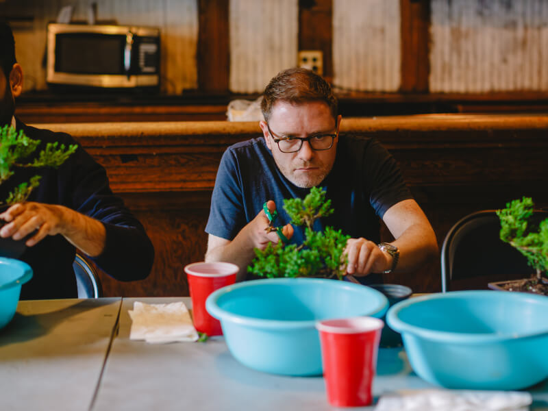 A man enjoys a mindful moment at a bonsai class