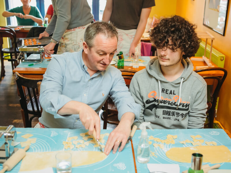 A smiling father enjoys a cooking class