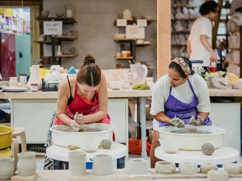 Couple focusing on wheel throwing at pottery for couples