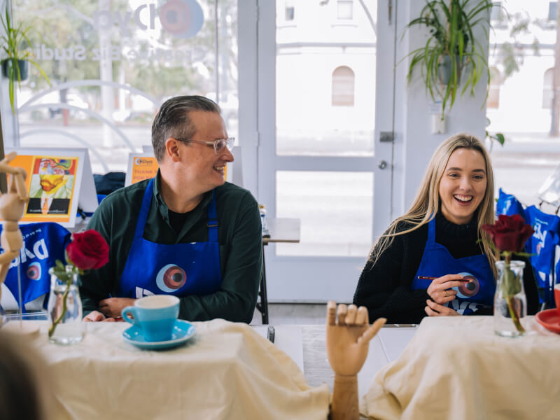 A man and woman smiling at a drawing class in Melbourne