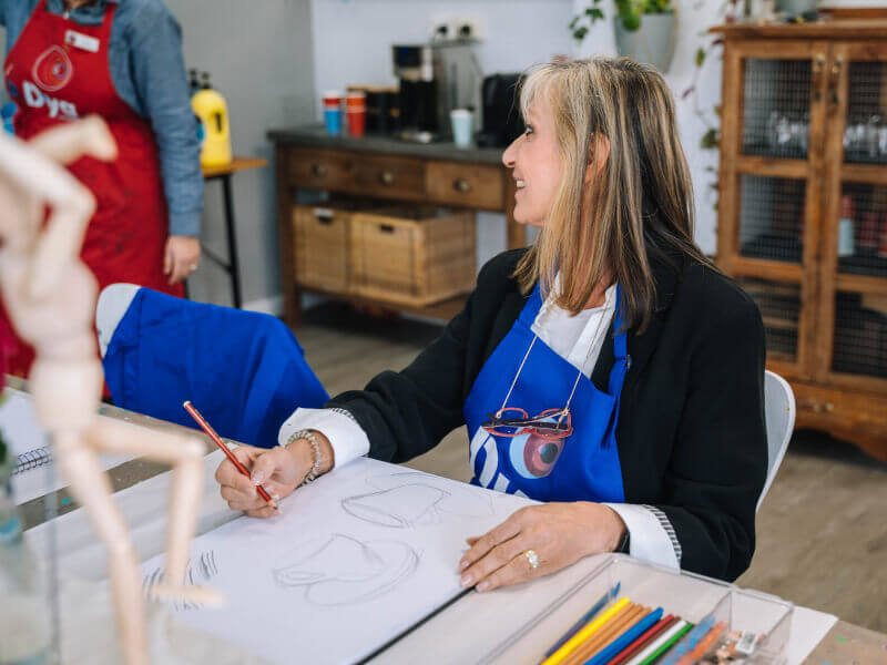 A woman sketches cups at a drawing class