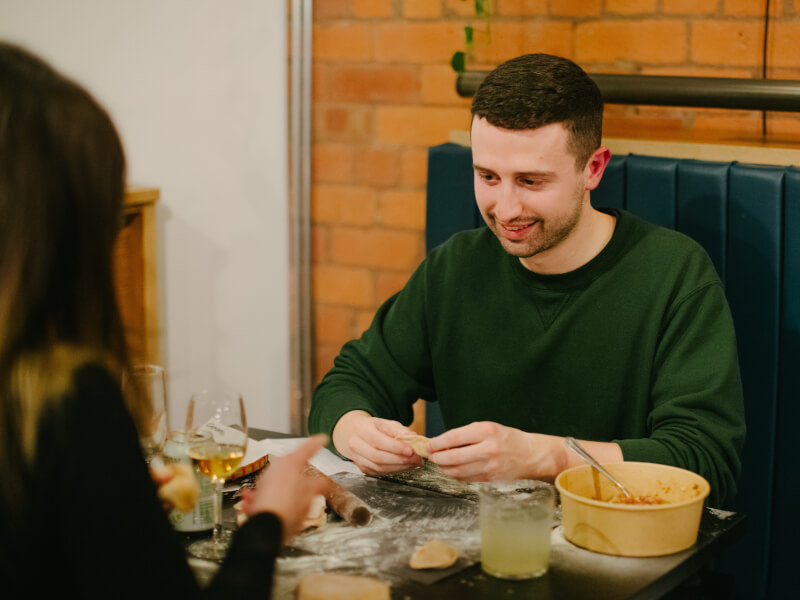 A smiling man attending a dumpling making workshop for Valentine's Day experiences