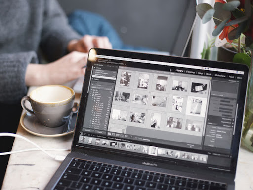 A person edits photos on their laptop
