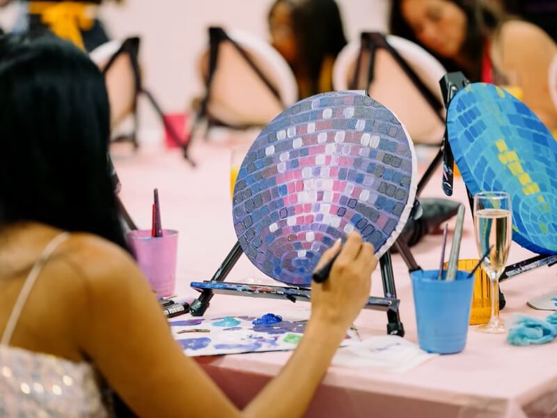 Painting a disco ball in a paint and sip class