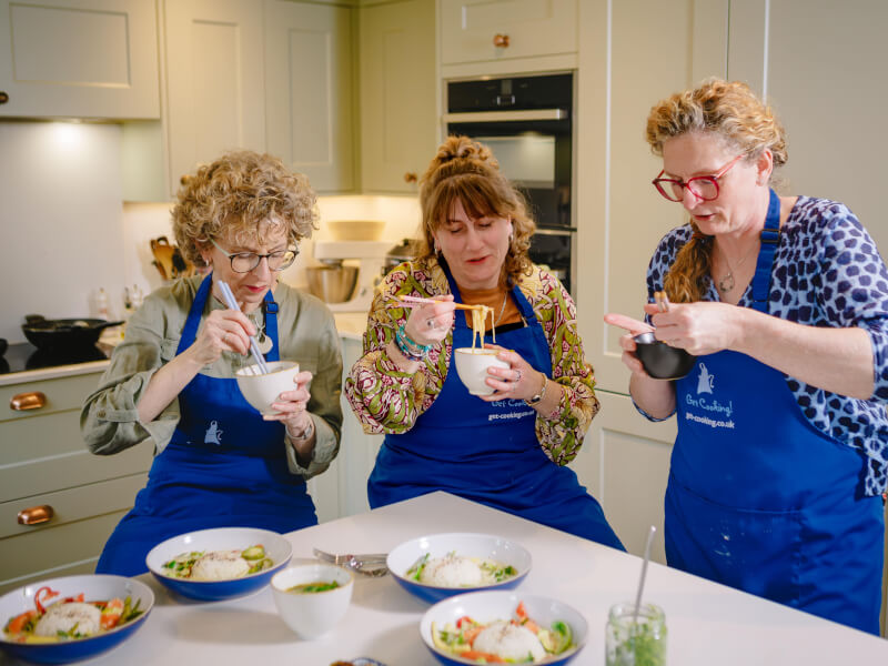 Three women enjoy a Mother's Day feast with food they made at a cooking class