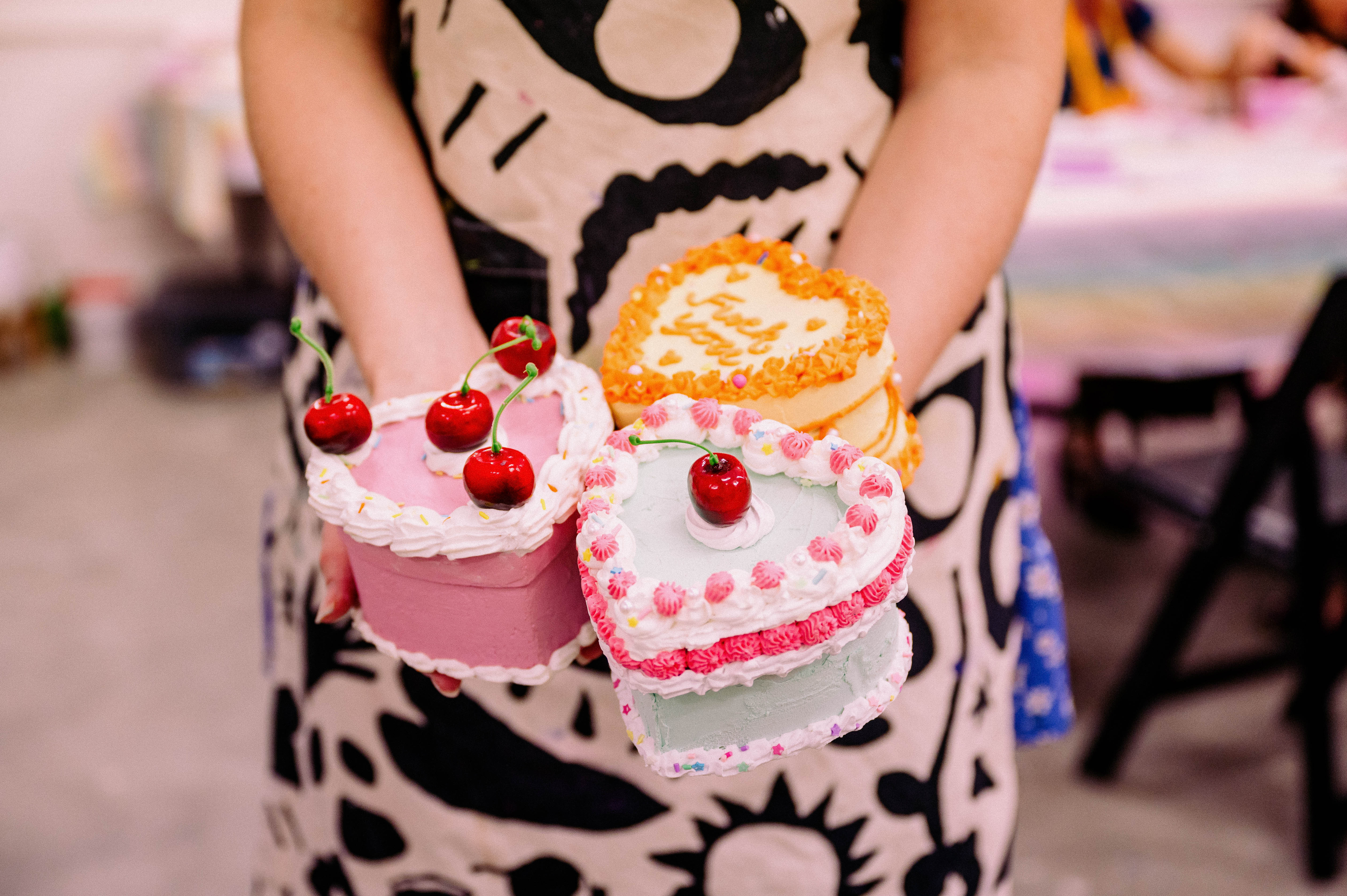 Person holding fake cake jewellery boxes in their hands