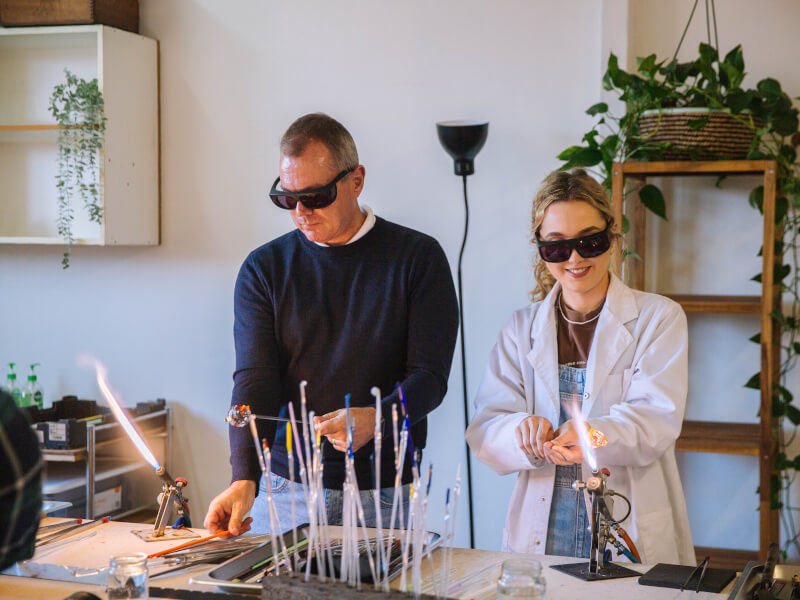A father and daughter bonding at a glass blowing workshop