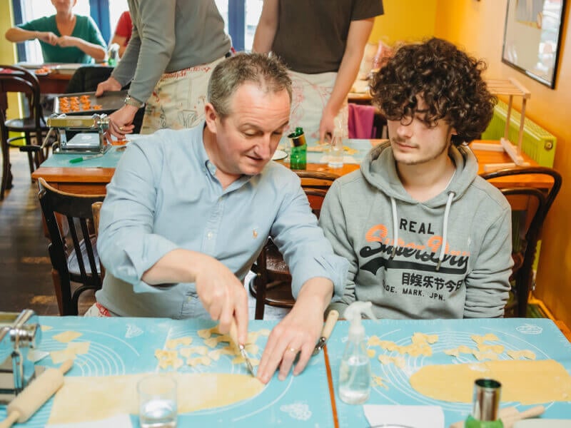 A father and son bonding at a pasta making class