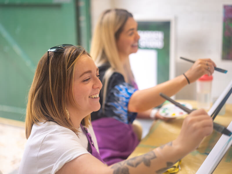 Couple smiling on a painting date