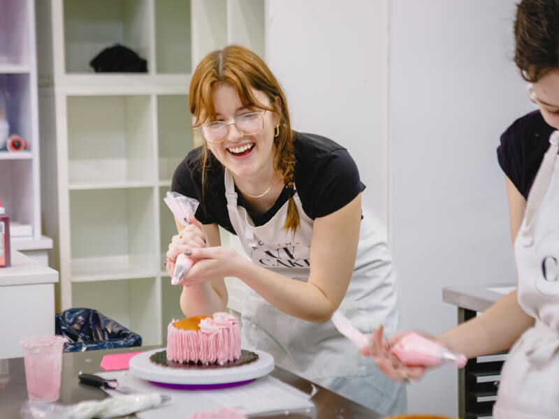 A woman decorates a cake at her work Christmas party