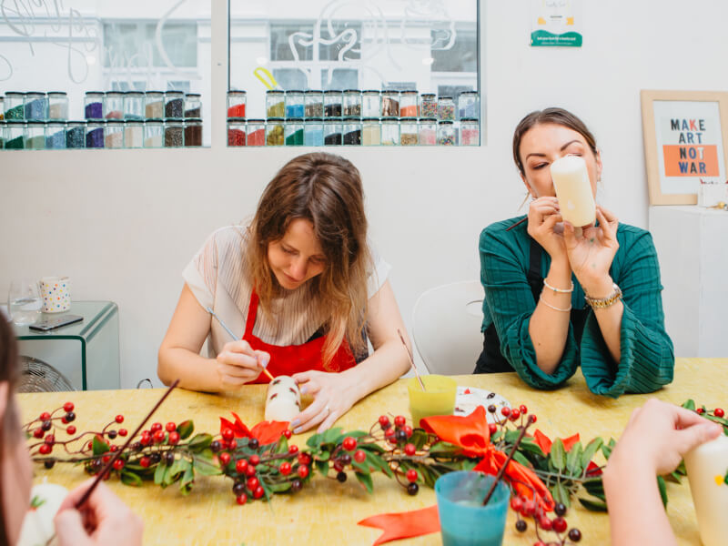 Friends make festive candles at a craft class