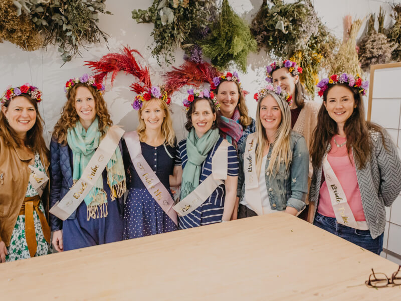 A group of women pose with their flower crowns at a hen party