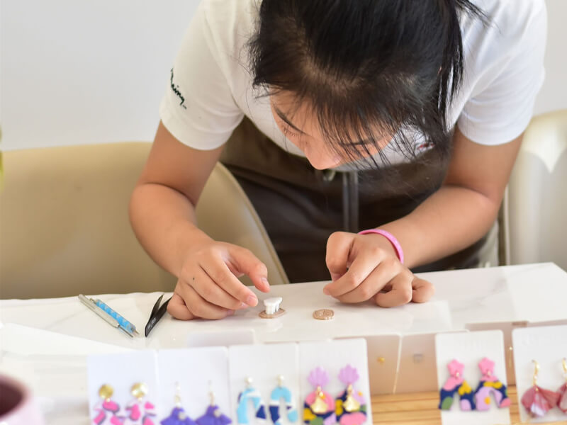 A woman focused on making earrings