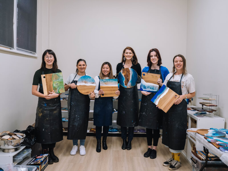 A group of girlfriends show off their handmade resin boards
