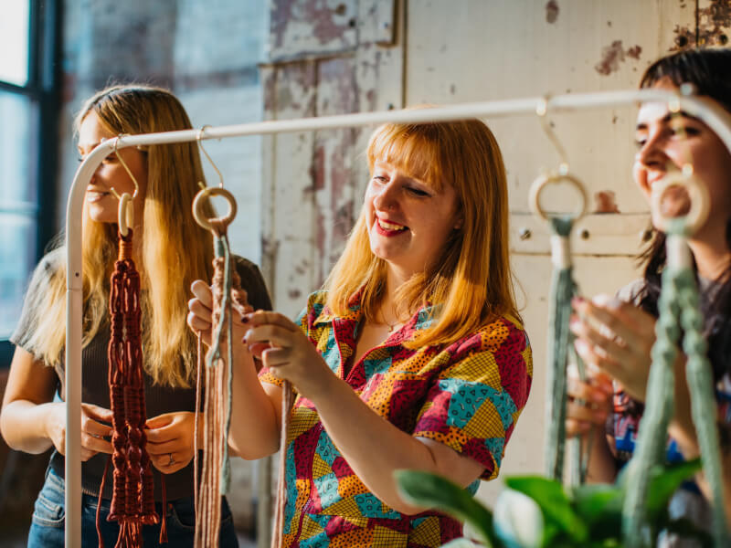 Three women make macrame plant hangers
