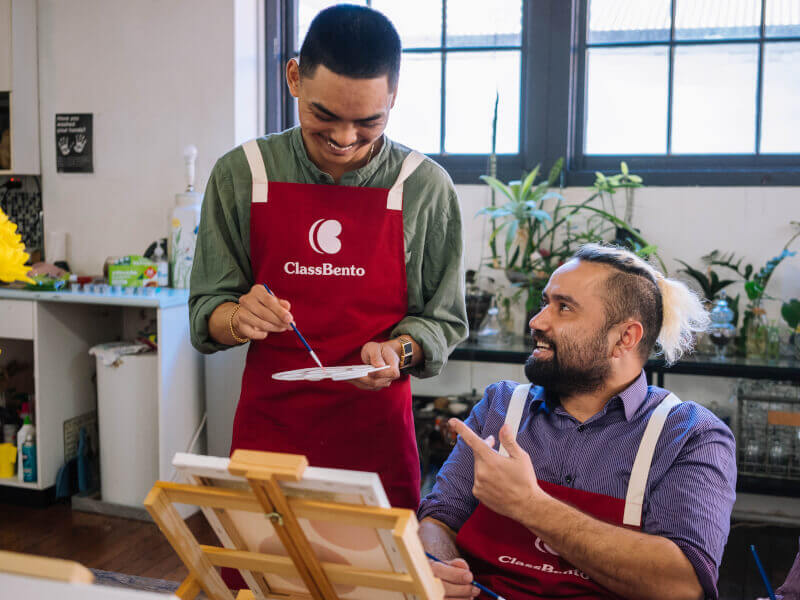 An art teacher helps a student with their painting