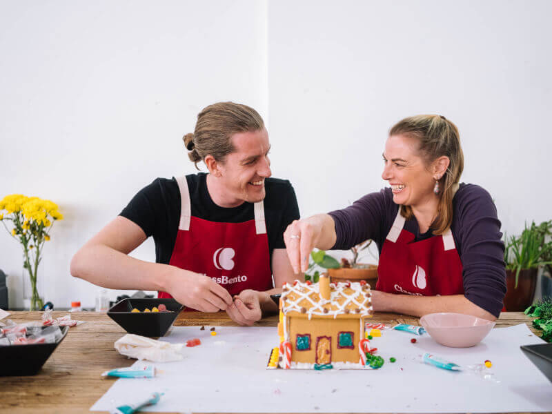 A couple making a gingerbread house for christmas