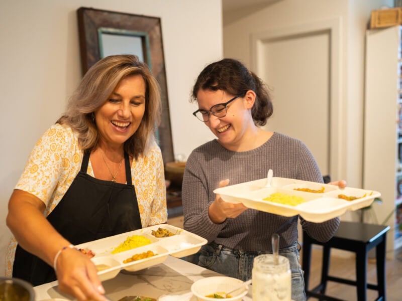 Daughter and Mum helping themselves to food at cooking class