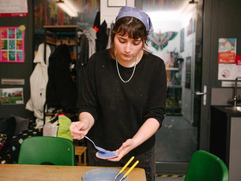 Woman painting a plate blue