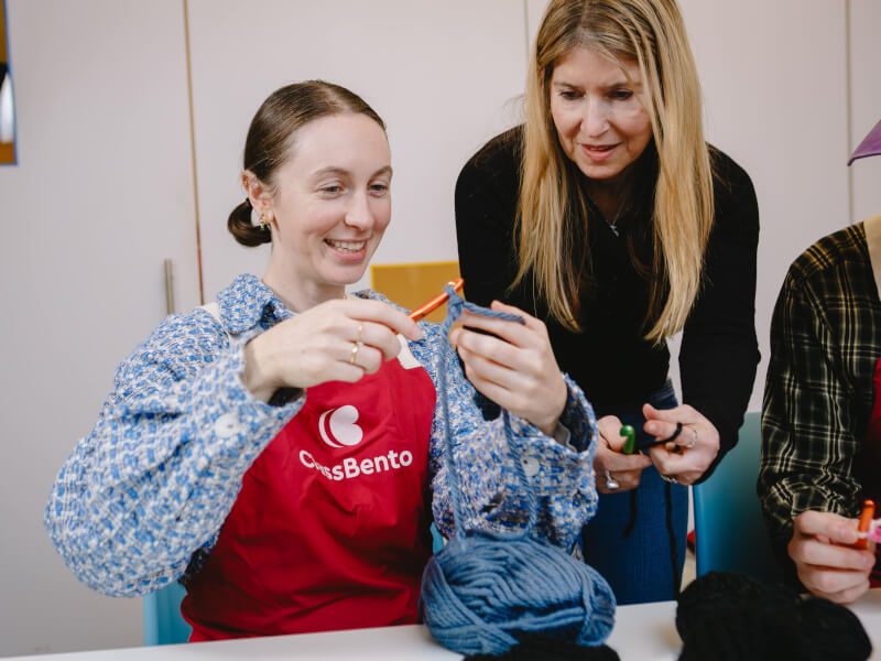 A girl learning to knit in a class