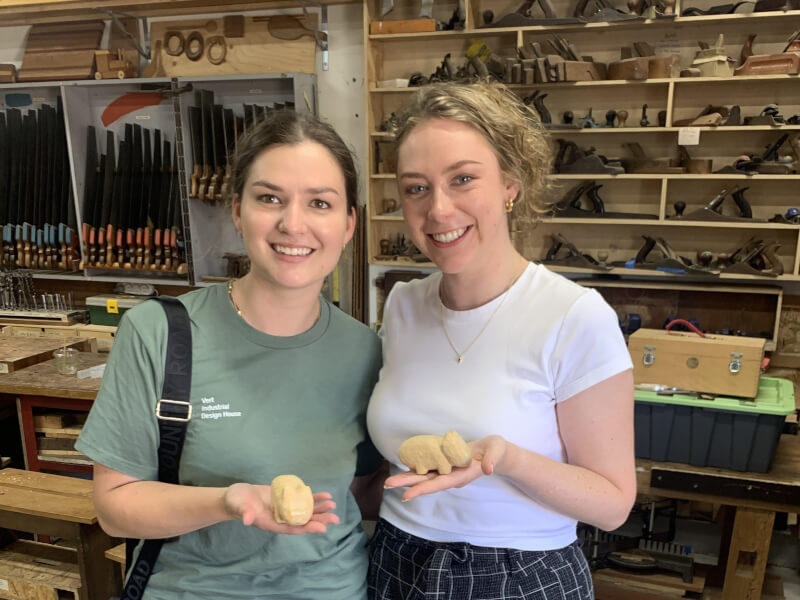 Two friends happy with their whittled animals