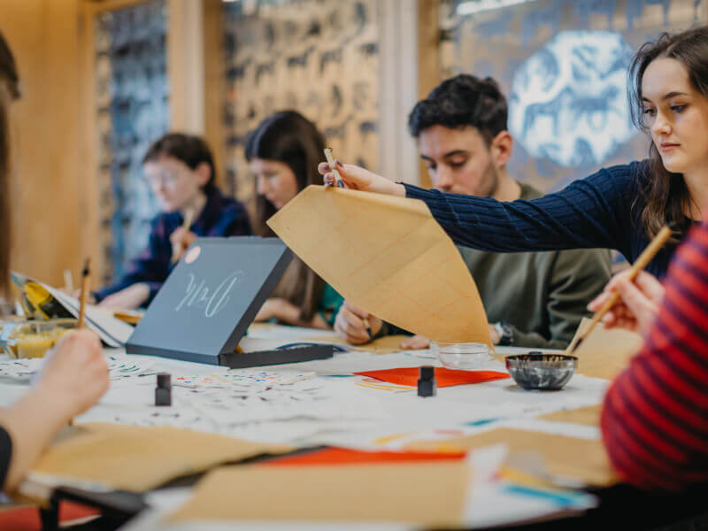 A group practices drawing on grid paper
