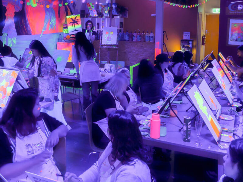 A fun group celebration for women at neon paint and sip class