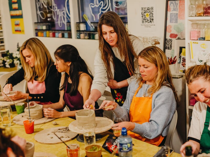 A group of women celebrating at a pottery workshop