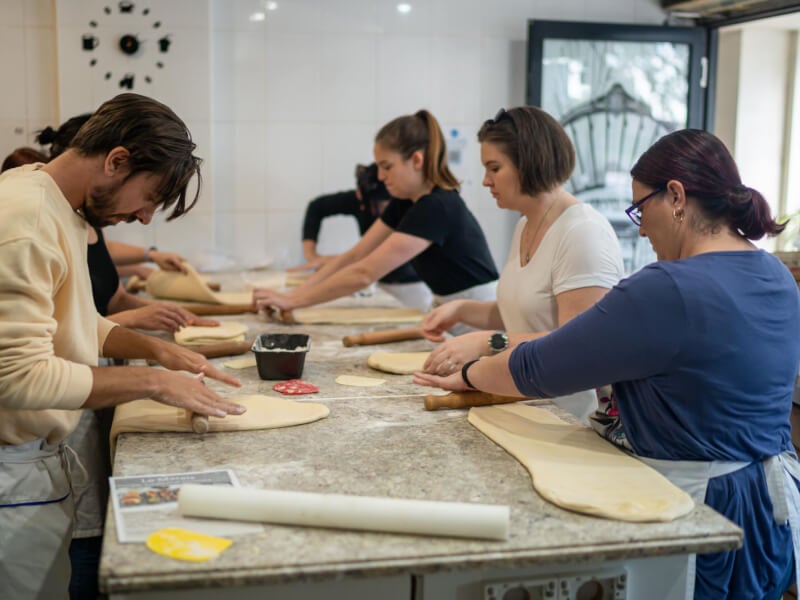 People rolling out croissant dough at baking class