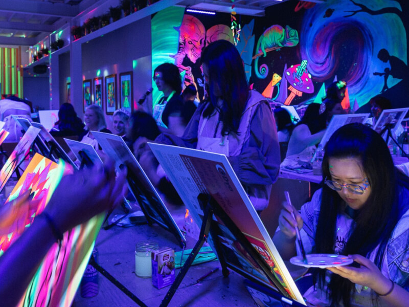 Neon room with friends enjoying glow in the dark painting for friendsmas