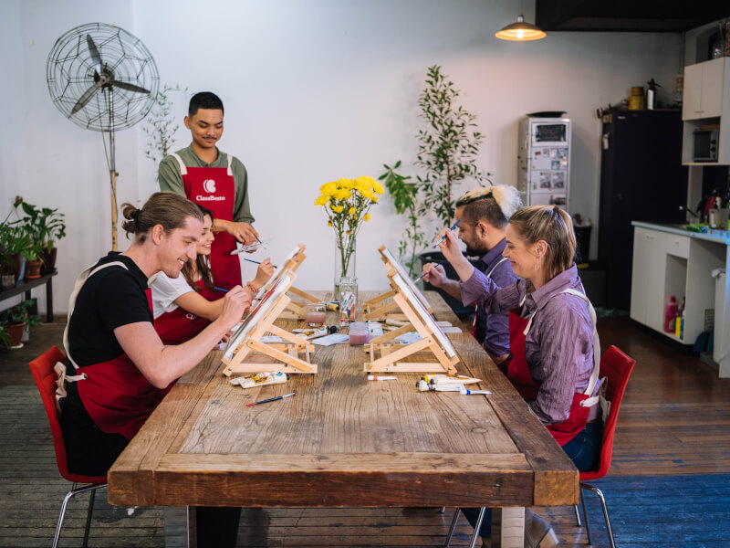 Group of people enjoying a painting workshop in Perth with mini easels