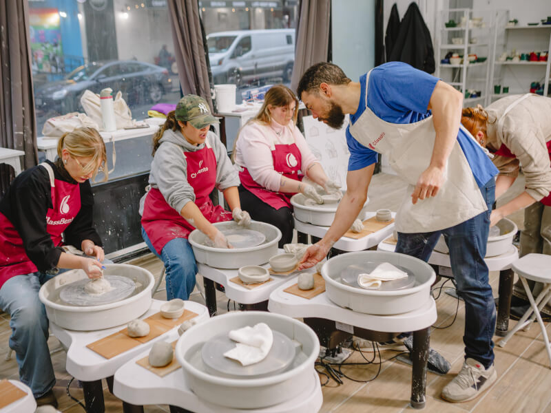 A group of people celebrate a birthday with a group pottery class