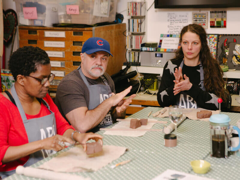 A father and daughter make mugs at a pottery class