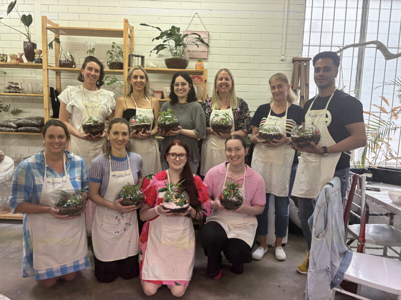A group of friends pose with their terrariums