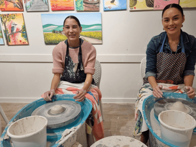 friends at a wheel throwing pottery workshop