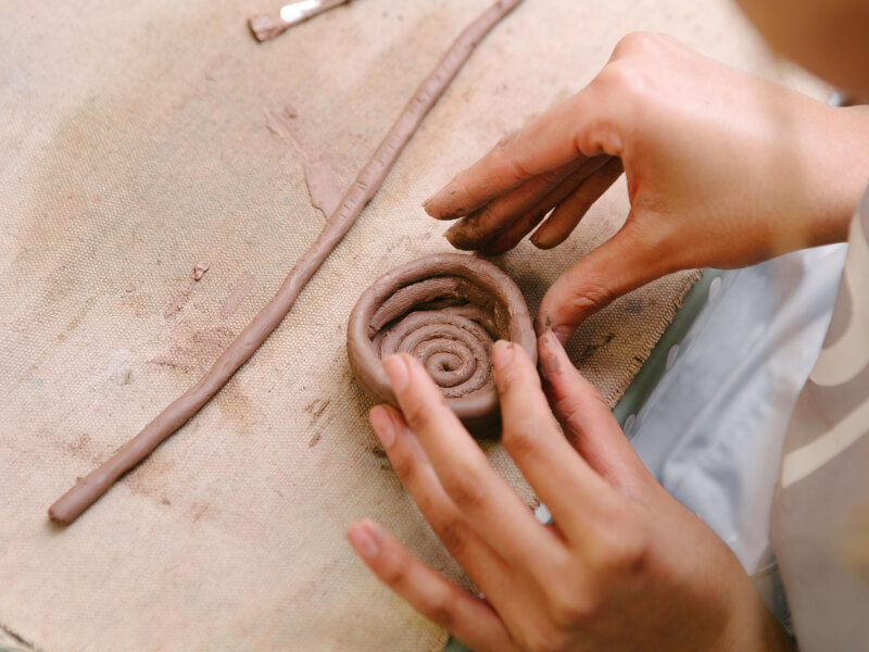 Hands in the process of making a mug out of clay